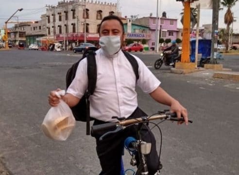 Este sacerdote lleva despensas en bicicleta a los más necesitados