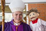 El Cardenal Aguiar con 'Monsi' el muñeco que fascina a los niños hablándoles de Jesús.