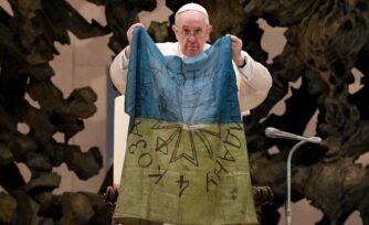 ¡Fin a la guerra! pide el Papa con una bandera de ciudad masacrada