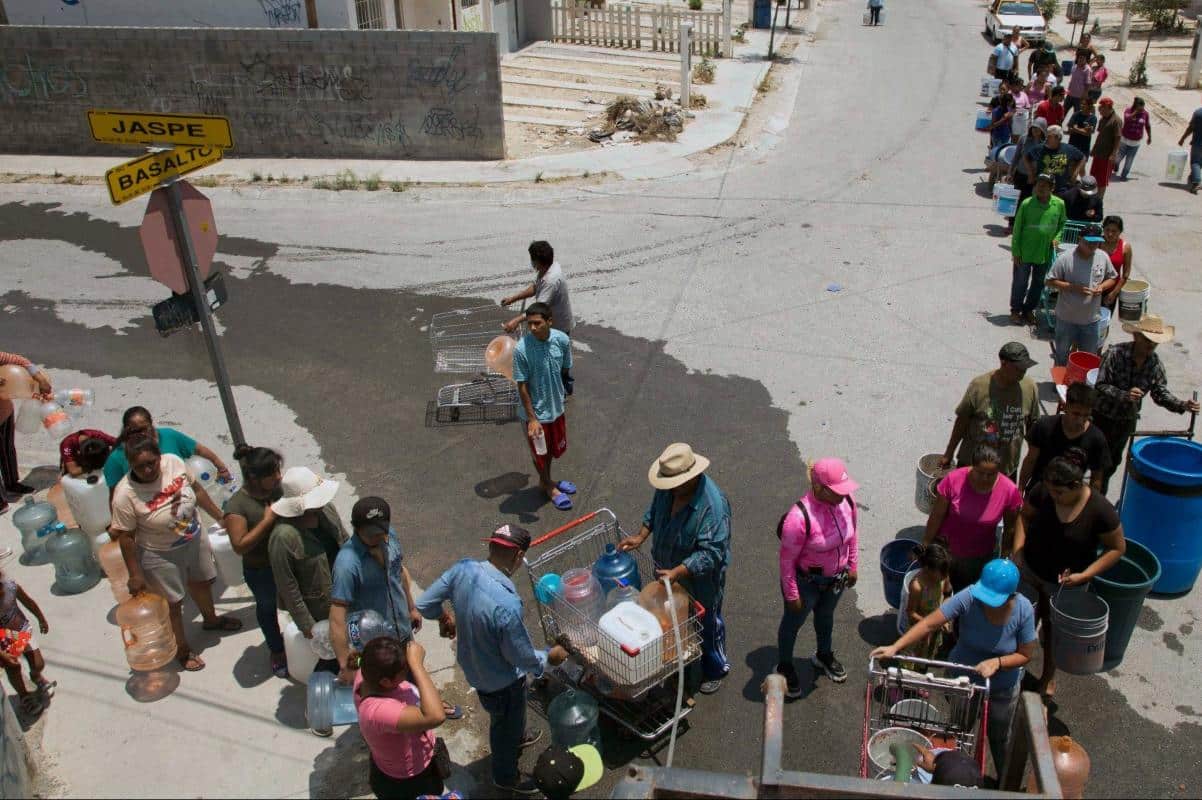 Habitantes de Monterrey hacen fila frente a una toma para garantizar el abasto para sus necesidades. Foto: Getty Images.