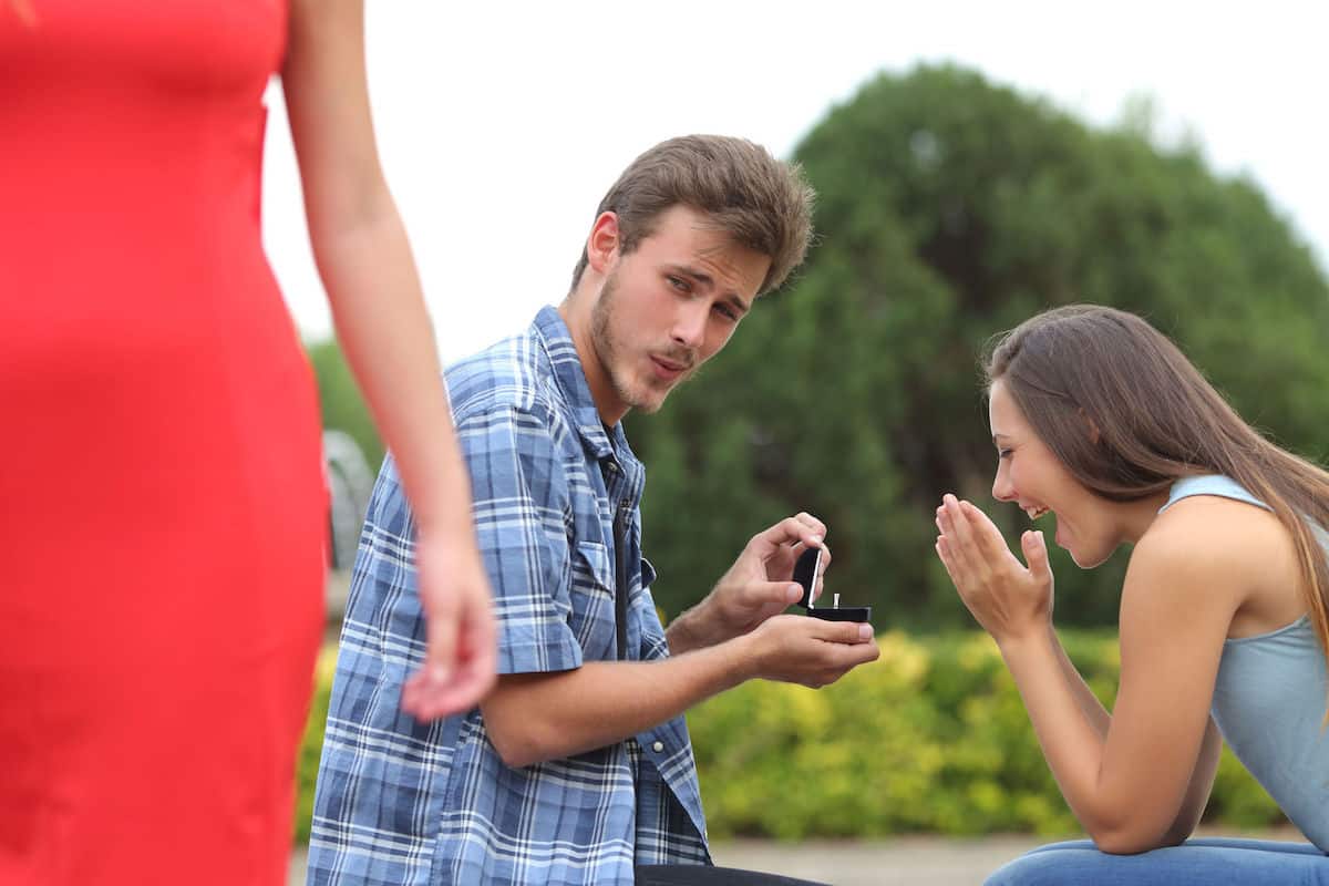 Joven entregando el anillo de bodas mientras ve a otra mujer