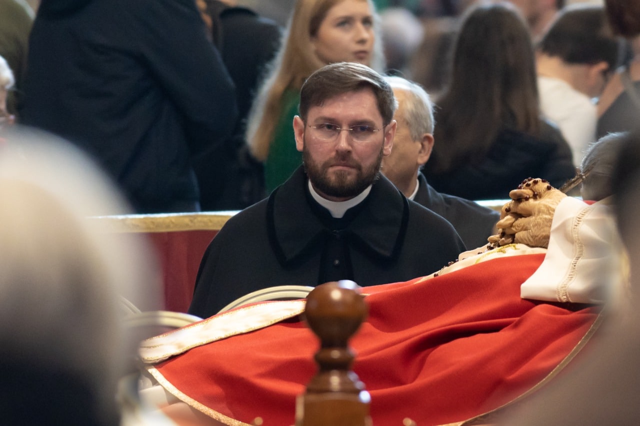 El sacerdote polaco Aleksander Iwaszczonek frente al cuerpo del Papa emérito Benedicto XVI/ Foto: Aleksander Iwaszczonek