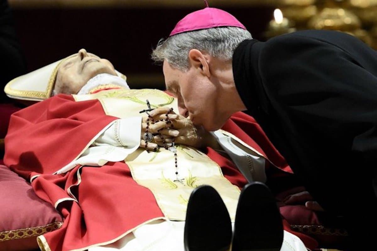 Durante los funerales monseñor Georg Ganswein besa las manos del cuerpo inerte del Papa emérito Benedicto XVI / Foto: Especial