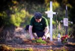 Una persona ora por su difunto en el panteón.