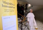 Papa León XIV caminando junto a cartel de la encíclica Magnifica Humanitas sobre inteligencia artificial y dignidad humana en el Vaticano.