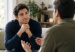Dos personas conversan mientras una escucha atentamente a la otra, ilustrando la importancia de la escucha activa, la empatía y la comunicación efectiva.